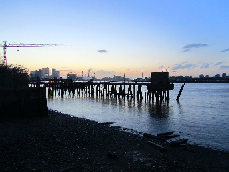 the sun going down behind the O2 and Canary Wharf as seen from near Durham Wharf