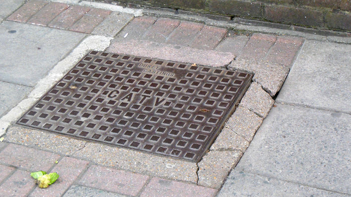 cable TV joint box sitting proud of
                          the pavement