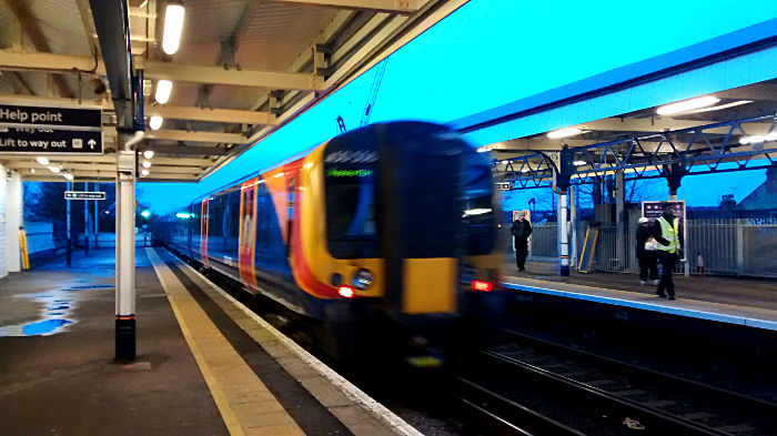 blurry image of class 450 train
                          leaving Earlsfield station