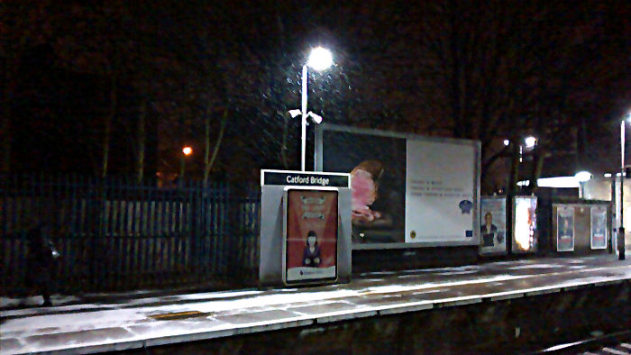 snow swirling past a platform light at
                          Catford Bridge station