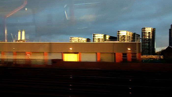 brilliant sunshine falling on high buildings
                  against a very dark sky