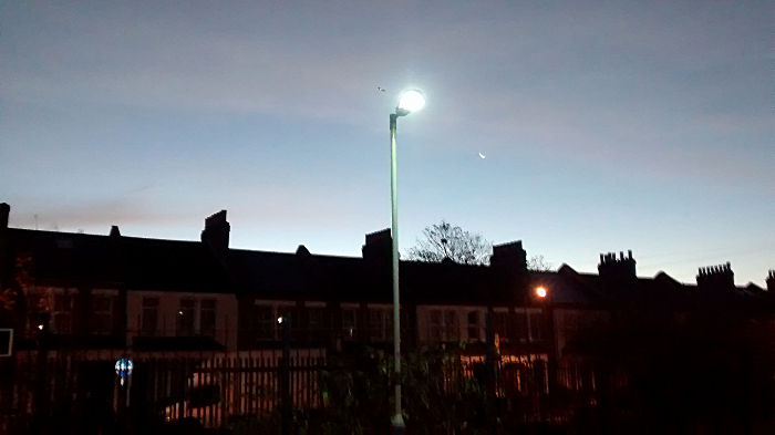 a thin crescent moon
                  outshone by a lamp