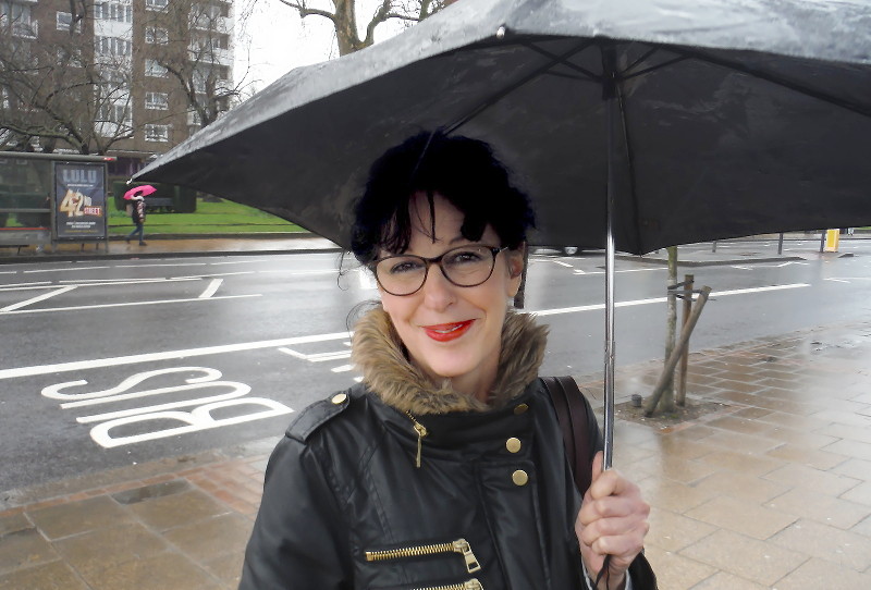 Angela under her umbrella in the
                              rain