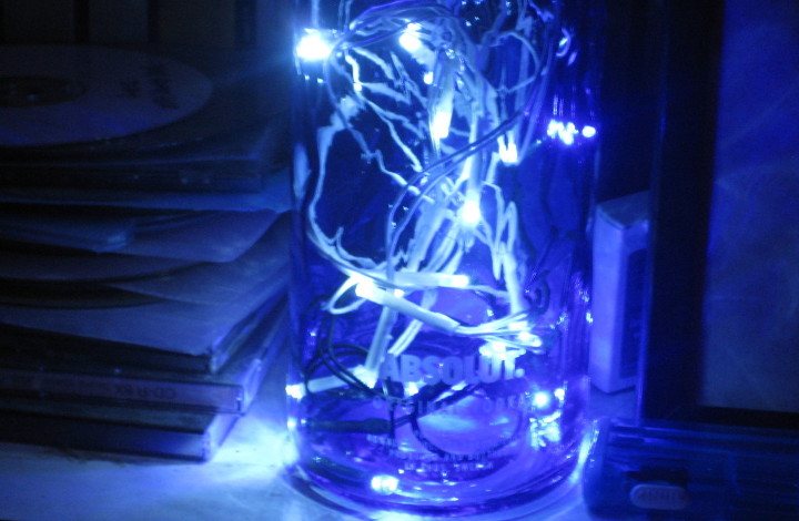 blue and white lights
                        in a blue Absolut bottle